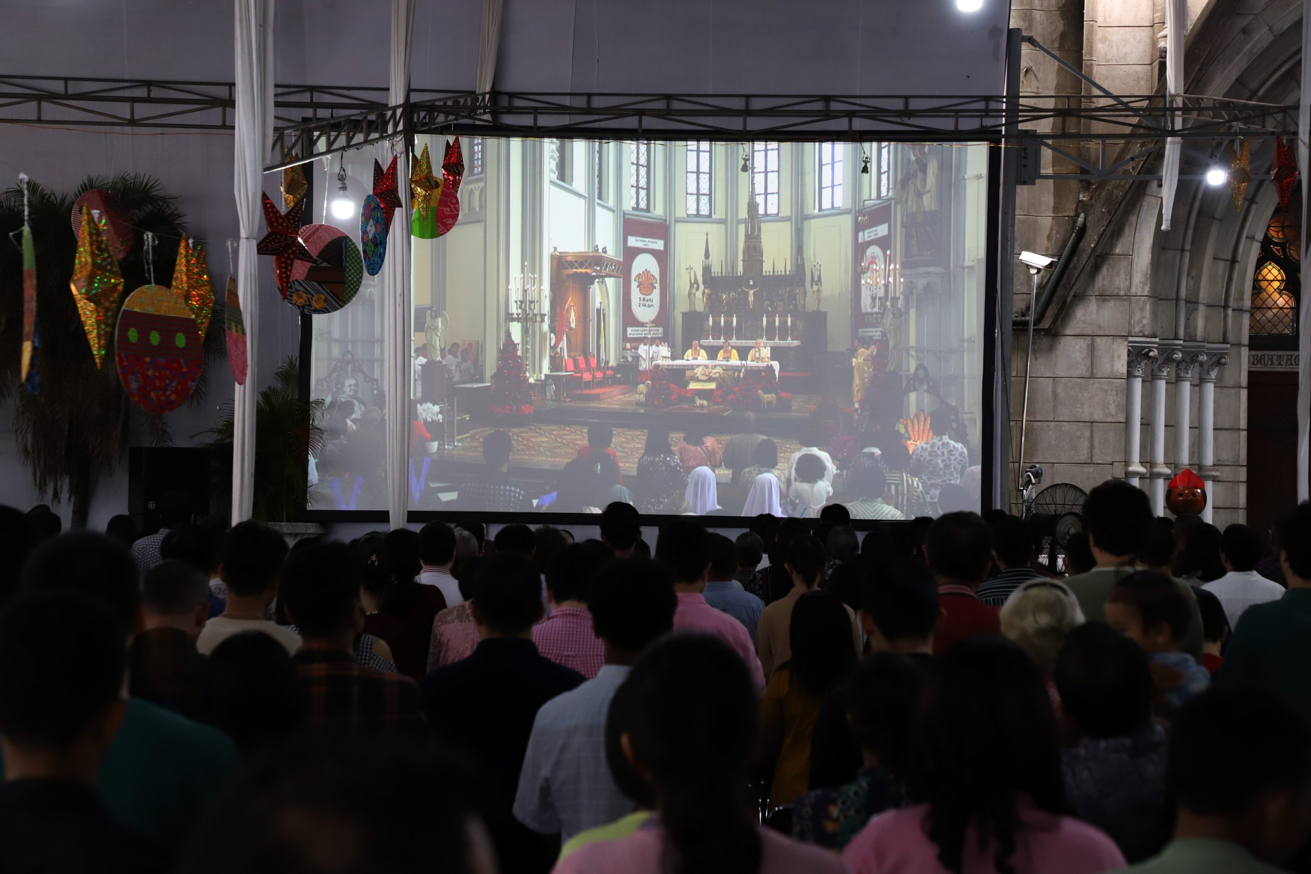 Umat kristiani mengikuti ibadah natal dengan penuh khidmat di Gereja Katedral, Jakarta. Walaupun hanya bisa mengikuti ibadah dari luar gedung utama, umat kristiani tetap menjalankan ibadah dengan penuh ke khusuyuan. | Foto:  Media Asuransi/Arief Wahyudi