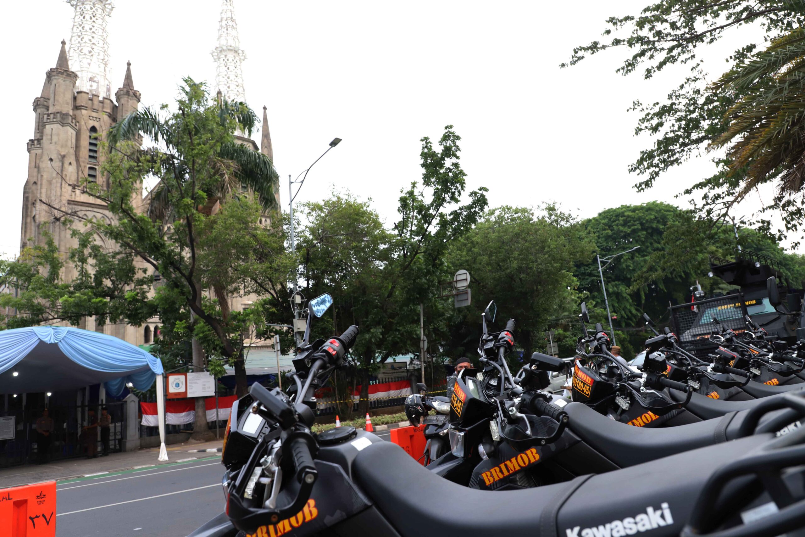 Sejumlah kendaraan polisi berderet di depan Gereja Katedral, Jakarta, Minggu, 24 Desember 2023. | Foto: Arief Wahyudi
