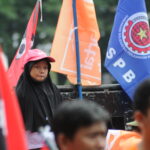 Seorang anak kecil diantara demo buruh yang terjadi pada 1 Mei 2023. | Foto: Arief Wahyudi