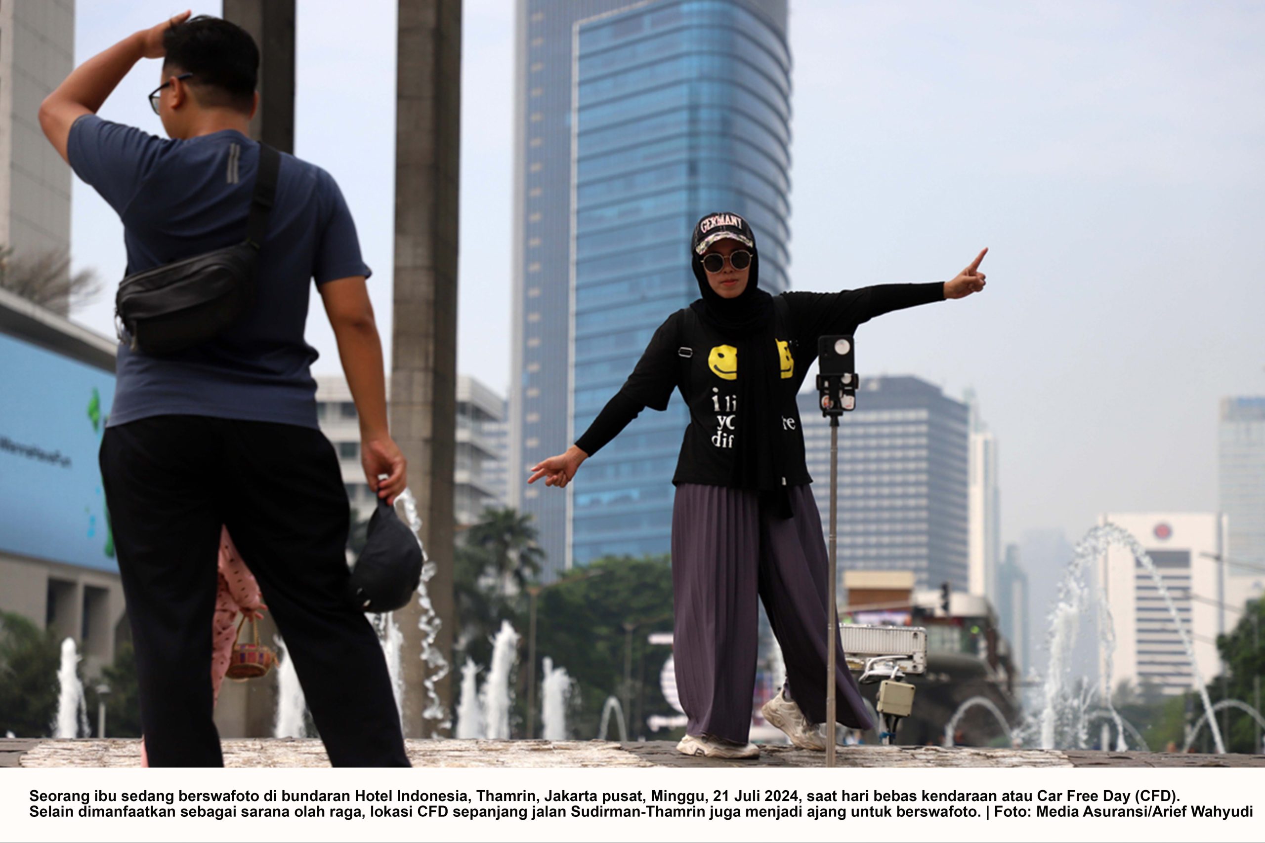 Seorang ibu sedang berswafoto di bundaran Hotel Indonesia, Thamrin, Jakarta pusat, Minggu, 21 Juli 2024, saat hari bebas kendaraan atau Car Free Day (CFD). 
Selain dimanfaatkan sebagai sarana olah raga, lokasi CFD sepanjang jalan Sudirman-Thamrin juga menjadi ajang untuk berswafoto. | Foto: Media Asuransi/Arief Wahyudi