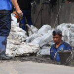 Petugas Suku Dinas (Sudin) Sumber Daya Air Jakarta selatan, sedang membersihkan gorong-gorong dan saluran air di sepanjang jalan raya Cileduk. | Foto: Arief Wahyudi