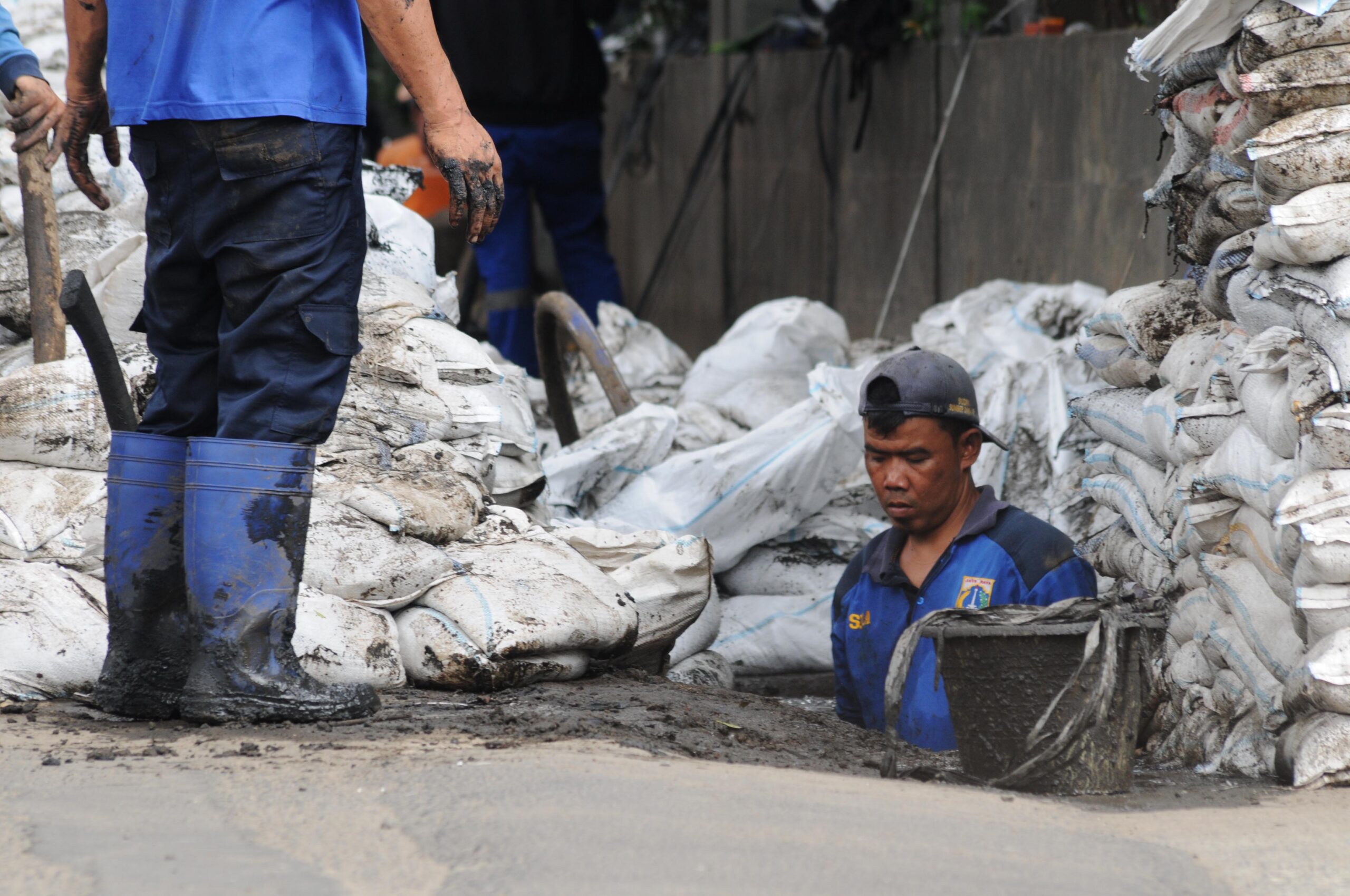 Petugas Suku Dinas (Sudin) Sumber Daya Air Jakarta selatan, sedang membersihkan gorong-gorong dan saluran air di sepanjang jalan raya Cileduk. | Foto: Arief Wahyudi