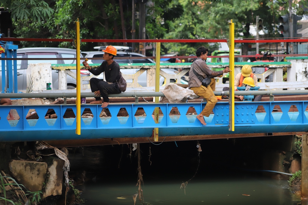 Pekerja saat melakukan perawatan fasilitas jembatan dengan melakukan pengecetan di jalan Cileduk Raya, Jakarta Selatan. | Foto: Media Asuransi/Arief Wahyudi