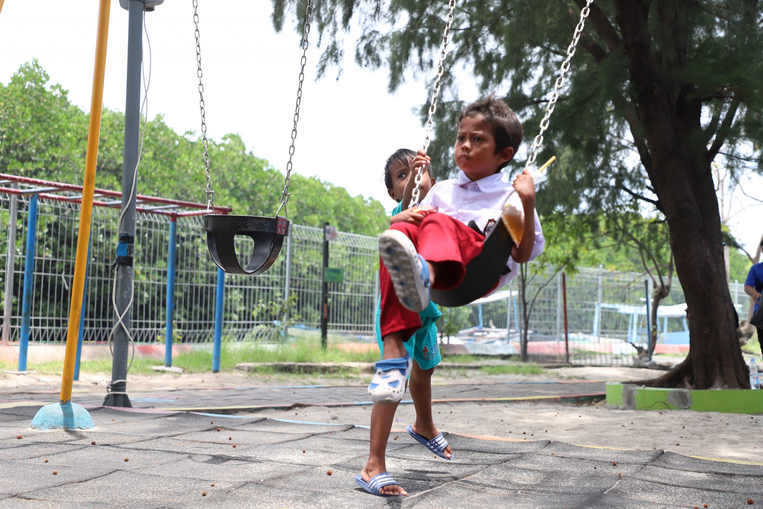 Anak-anak Pulau Panggang, Kepulauan Seribu asik bermain ayunan usai pulang sekolah. Pemerintah Pulau Panggang menyediakan fasilitas bermain anak sebagai salah satu sarana hiburan dan olahraga.  | Foto: Media Asuransi/Arief Wahyudi