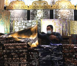 Seorang penjual kain sedang merapikan lembaran kain pada acara pameran UMKM di Jakarta, beberapa waktu lalu.