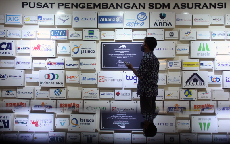 Karyawan memperhatikan deretan logo-logo perusahaan asuransi umum di kantor Asosiasi Asuransi Umum Indonesia (AAUI), di Jakarta, beberapa waktu lalu.