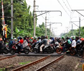 Sejumlah pengendara sepeda motor melintasi pintu rel Kereta Api (Commuter Line) di kawasan Bintaro, Tangerang Selatan. Jalur kereta di kawasan Bintaro terbilang jalur sibuk kereta, terutama di jam-jam sibuk kerja. | Foto: Media Asuransi/Arief Wahyudi