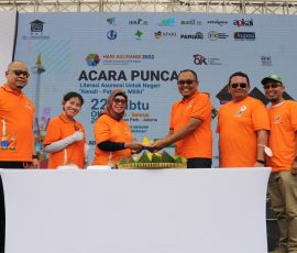 Ketua Panitia Hari Asuransi 2022 Retno Susanti menerima potongan tumpeng dari Ketua Umum Dewan Asuransi Indonesia (DAI) Tatang Nurhidayat, disaksikan pengurus DAI lainnya, pada puncak acara hari asuransi 2022, Sabtu, 22 Oktober 2022 di Senayan Park, Jakarta.