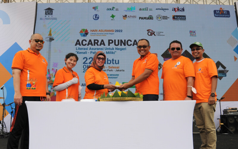 Ketua Panitia Hari Asuransi 2022 Retno Susanti menerima potongan tumpeng dari Ketua Umum Dewan Asuransi Indonesia (DAI) Tatang Nurhidayat, disaksikan pengurus DAI lainnya, pada puncak acara hari asuransi 2022, Sabtu, 22 Oktober 2022 di Senayan Park, Jakarta.