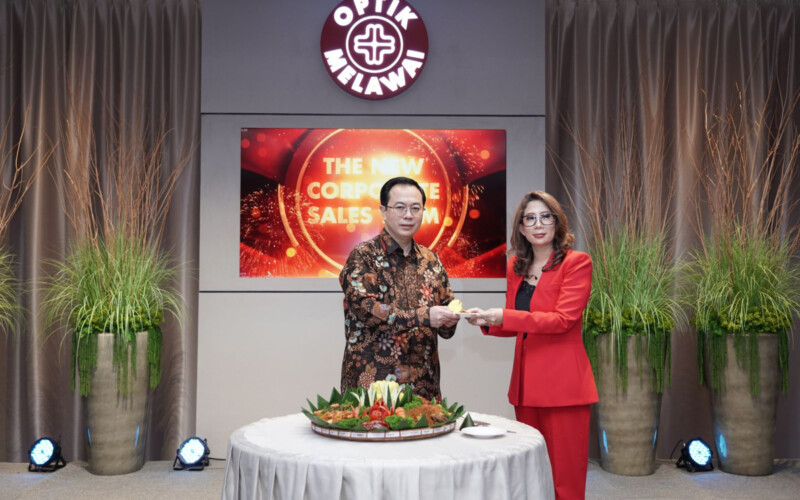 Managing Director Optik MelawaiEddyanto Hadisurjo(kiri) memberikan potongan tumpeng kepada Head ofCorporate Sales & Isurance Business Optik Melawai Endung Irmawati.