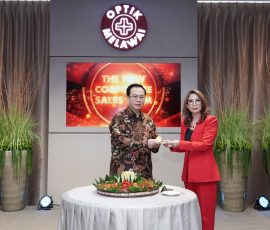 Managing Director Optik MelawaiEddyanto Hadisurjo(kiri) memberikan potongan tumpeng kepada Head ofCorporate Sales & Isurance Business Optik Melawai Endung Irmawati.