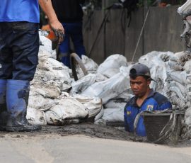 Petugas Suku Dinas (Sudin) Sumber Daya Air Jakarta selatan, sedang membersihkan gorong-gorong dan saluran air di sepanjang jalan raya Cileduk. | Foto: Arief Wahyudi